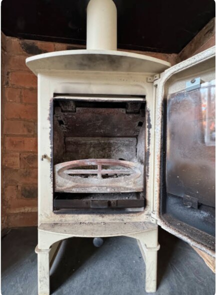 Cream cast-iron stove serviced and ready to relight